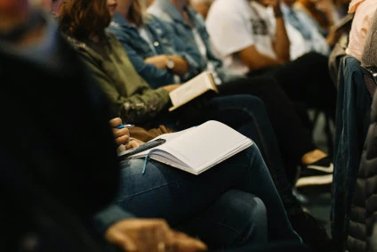 Personnes assises en train de prendre des notes